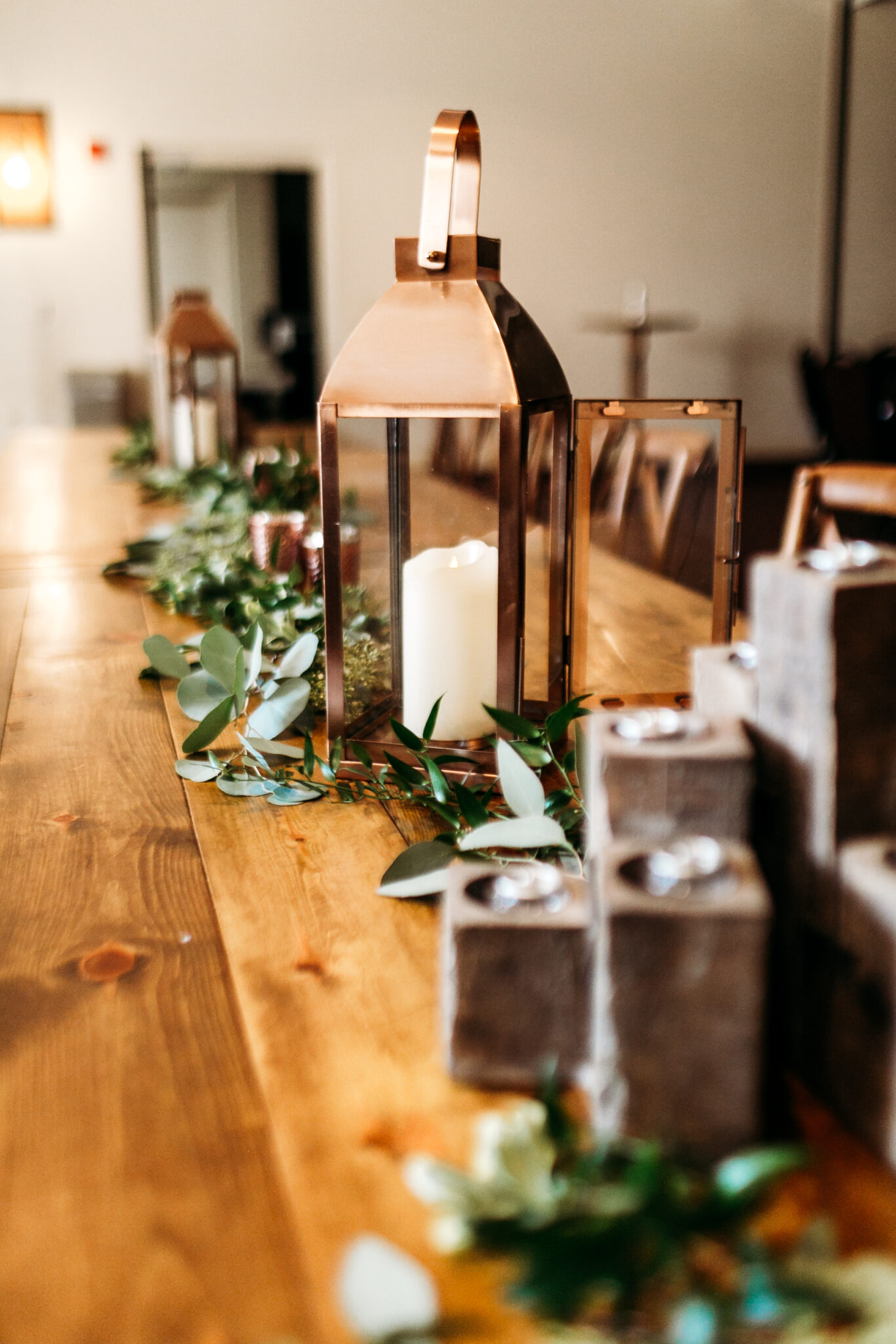 Brown candle holder and brown decorative candles on a long wood table