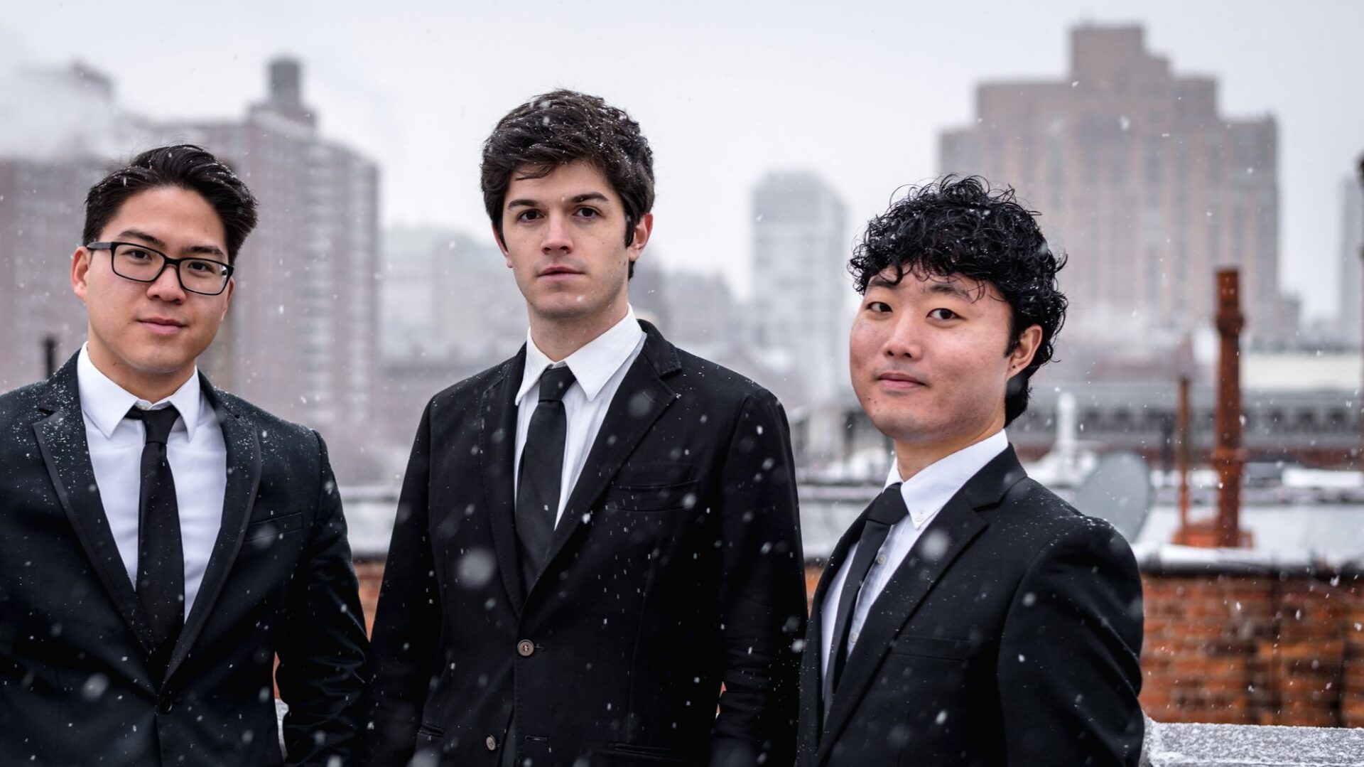 A picture of men wearing black suits in a snowy day