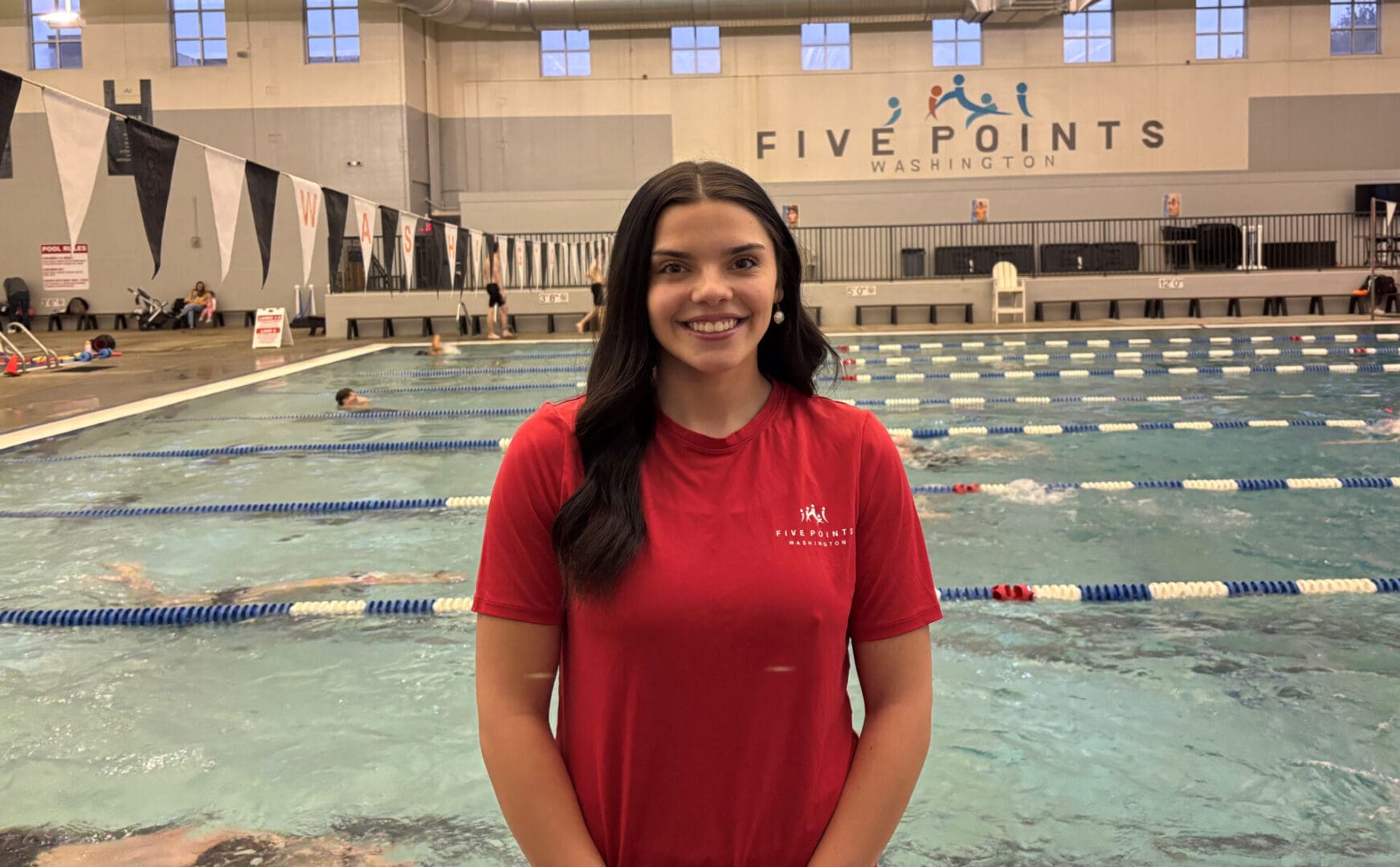 Woman in red shirt by swimming pool.