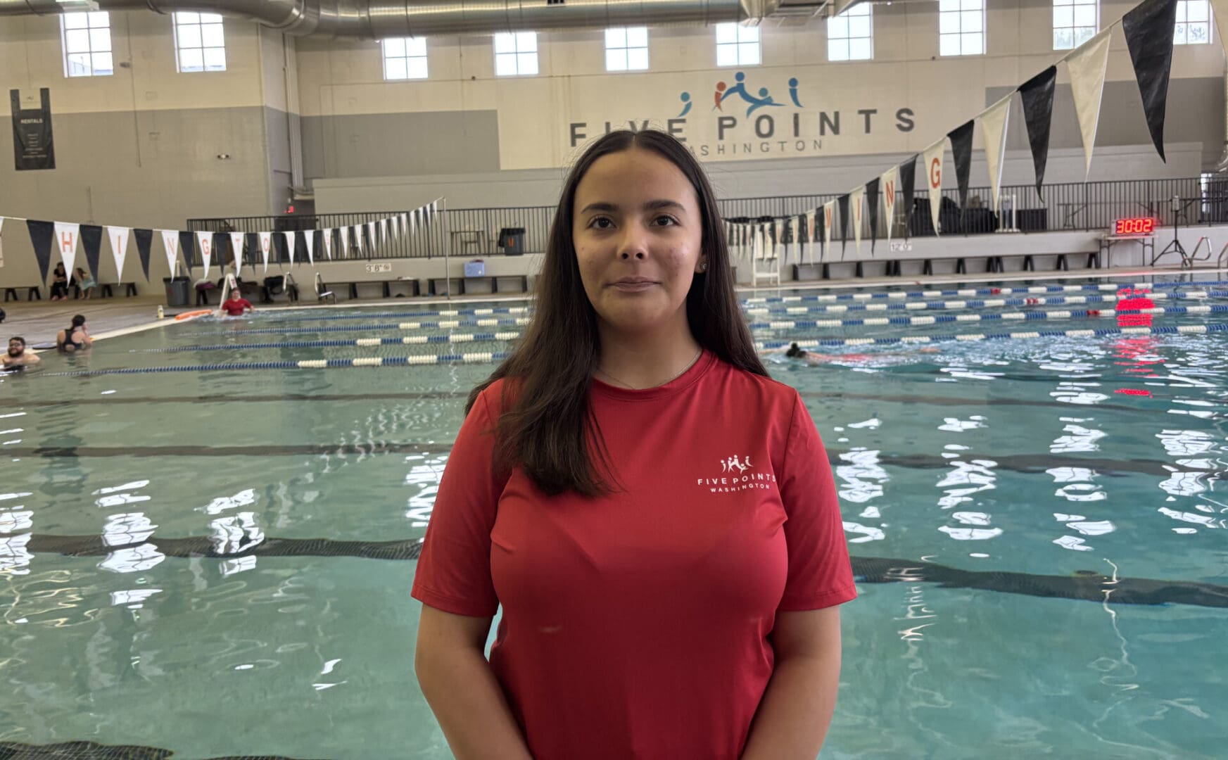 Woman standing in front of indoor pool.