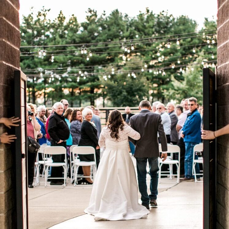 Bride and her escort walking down the aisle during an outdoor wedding ceremony